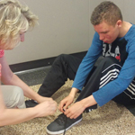 NJ special needs student learning to tie shoe