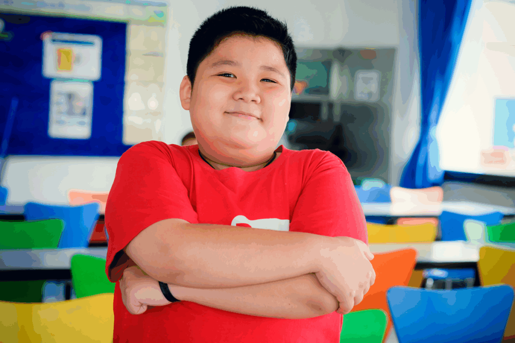 Asian boy standing crossed arms and cute smile.