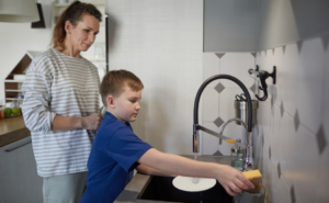 boy helping with chores in kitchen